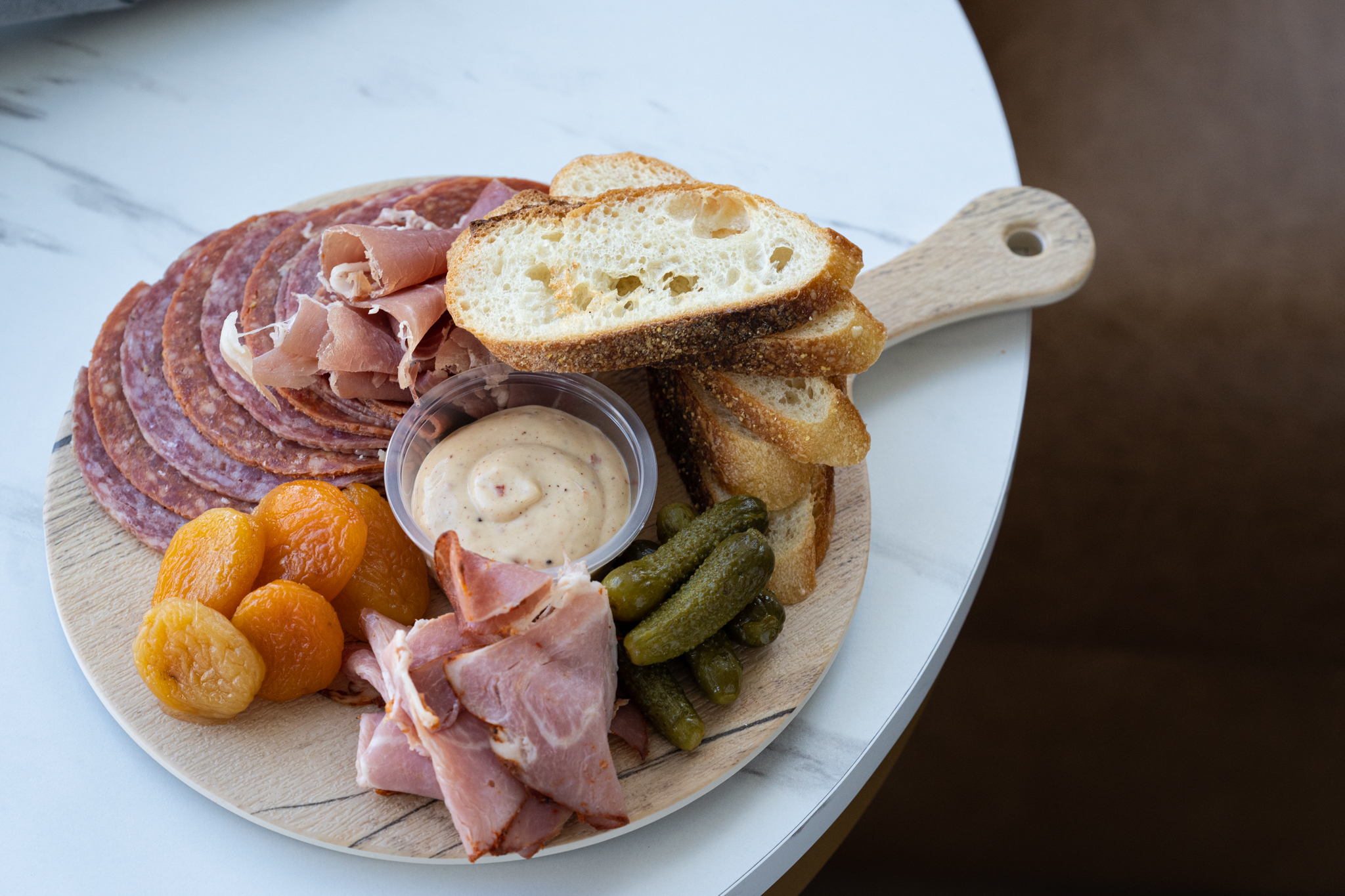 A meat board from Craft Lounge is artfully plated and placed on a marble table