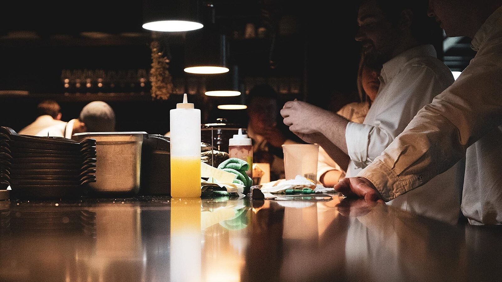 Cooks standing around a counter for a pre-shift meeting